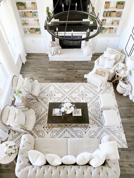 Neutral farmhouse living room and furniture layout with sofa and two chairs.