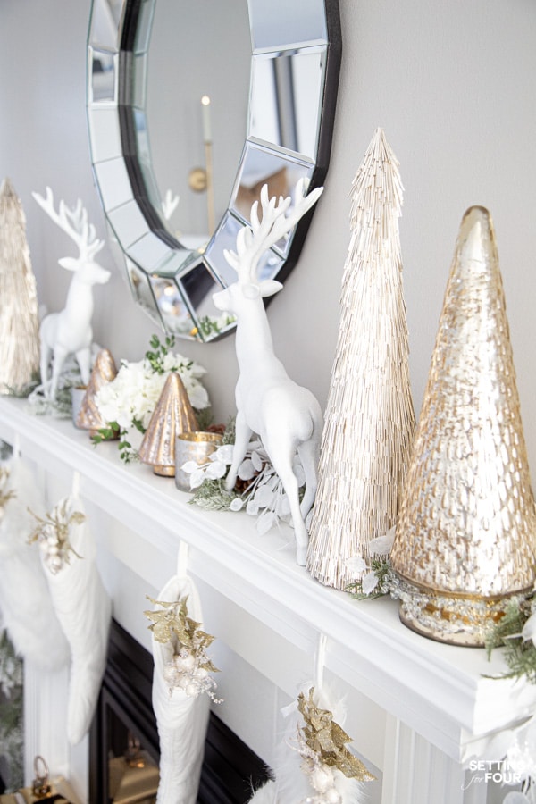 White and Gold Christmas Mantel Decor Ideas With Deer, Tinsel and Glass Christmas Trees.