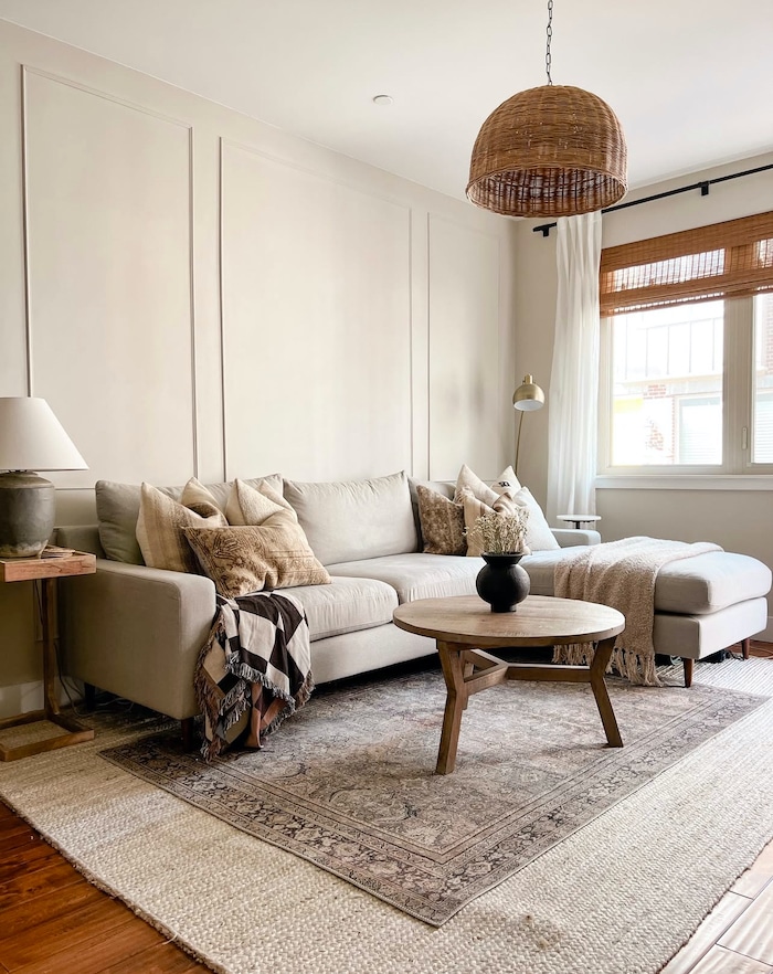 Sherwin Williams Agreeable Gray 50% Wall Color. living room paint color, neutral, cozy, elegant, modern, transitional, earthy, boho, painting, idea, layered rugs, sectional, small living room, wicker pendant light, natural, interior design idea 