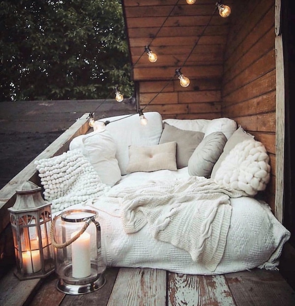 How To Create A Cozy Nook - Design and Decor Ideas. cozy outdoor balcony nook with pillows and throw blankets.