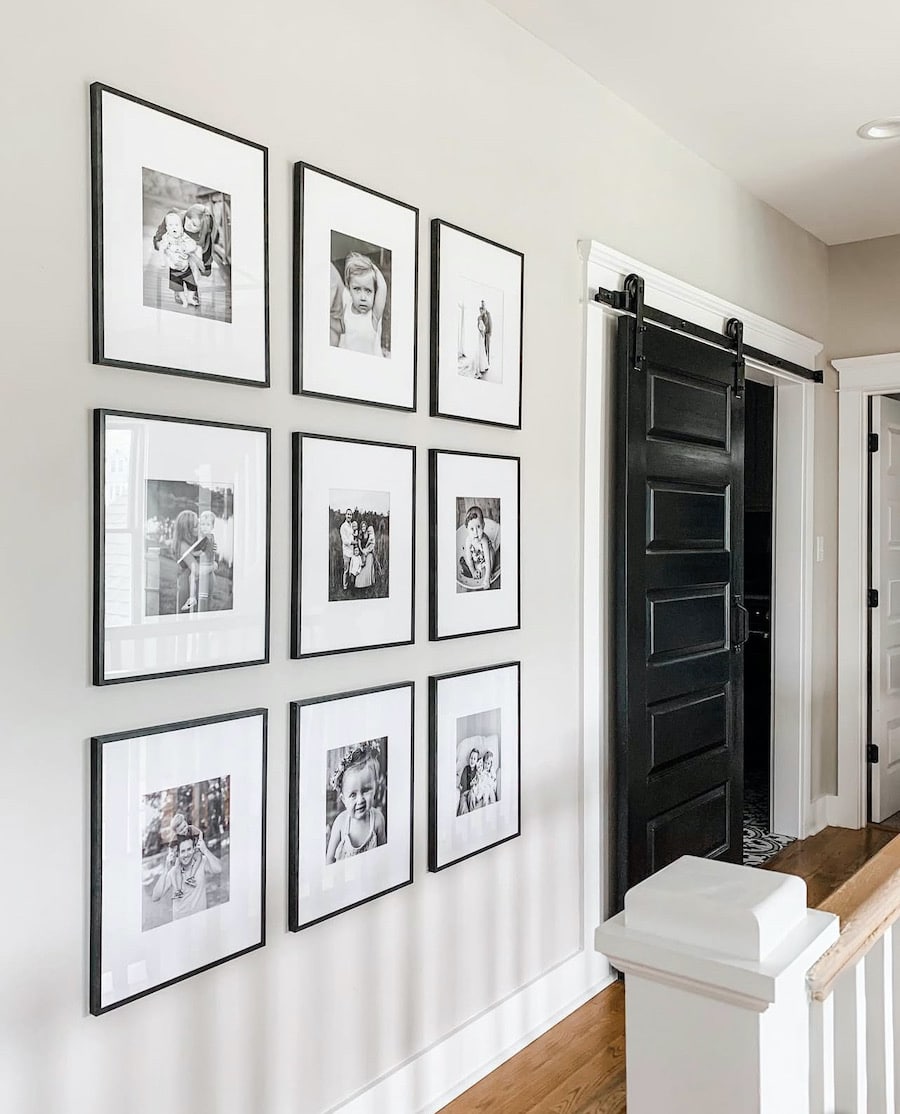 Sherwin Williams Repose Gray Hallway Paint Color Idea, greige wall color, gallery wall with black and white family photographs, black rolling barn door saves space in narrow hallway, cozy, organic modern, transitional, farmhouse design inspiration, new home ideas, 2026 trends