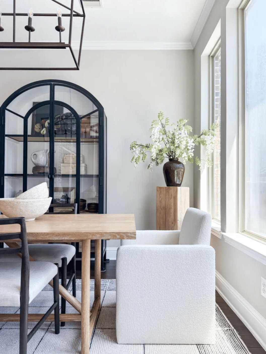 Sherwin Williams Repose Gray Kitchen Breakfast Nook Paint Color Inspiration, warm, griege, cozy, wood dining table with upholstered chairs, black arch cabinet storage idea, black lantern chandelier, black sideboard cabinet, organic modern, transitional, dark brown wood floors