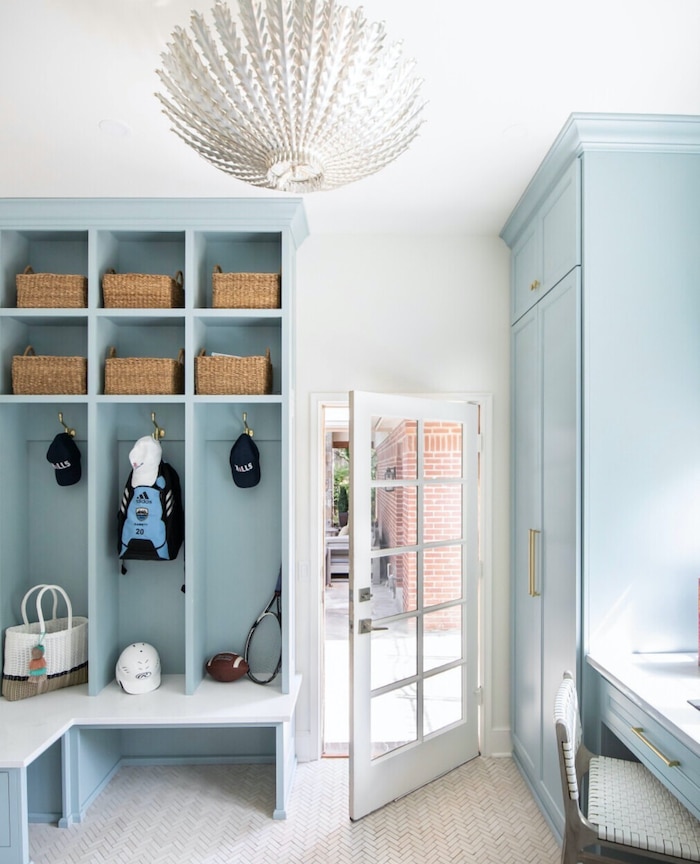 Beautiful Mudroom With Coastal Style. Elegant mudroom ceiling light idea. Builtins with hooks to hang backpacks and hats and baskets for storage. Mudroom desk idea.