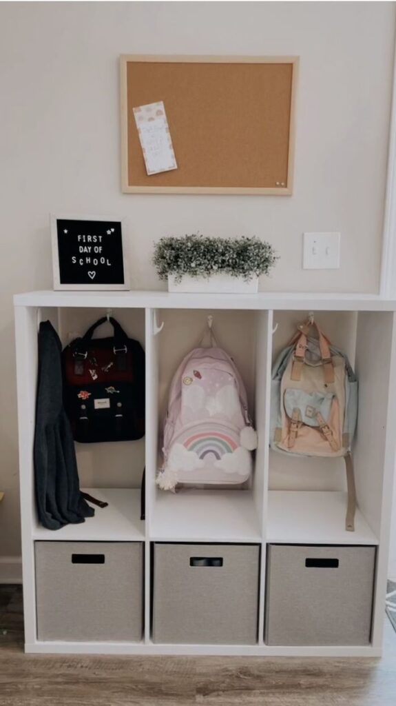 How To Use A Cube Cabinet To Organize Backpacks. A cube cabinet, hooks and fabric bins create a tidy kids backpack storage for a small entryway or mudroom.