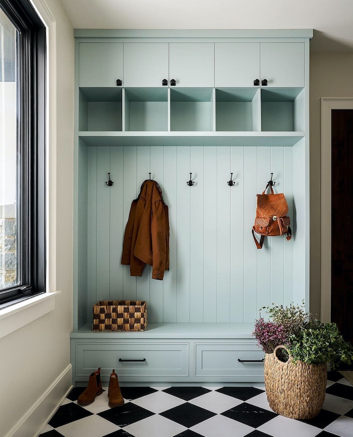 Beautiful Mudroom and Entryway Backpack Storage Ideas. Elegant hall tree cabinet with drawers, cubbies and hooks to hang backpacks. Black and white check tile floor.