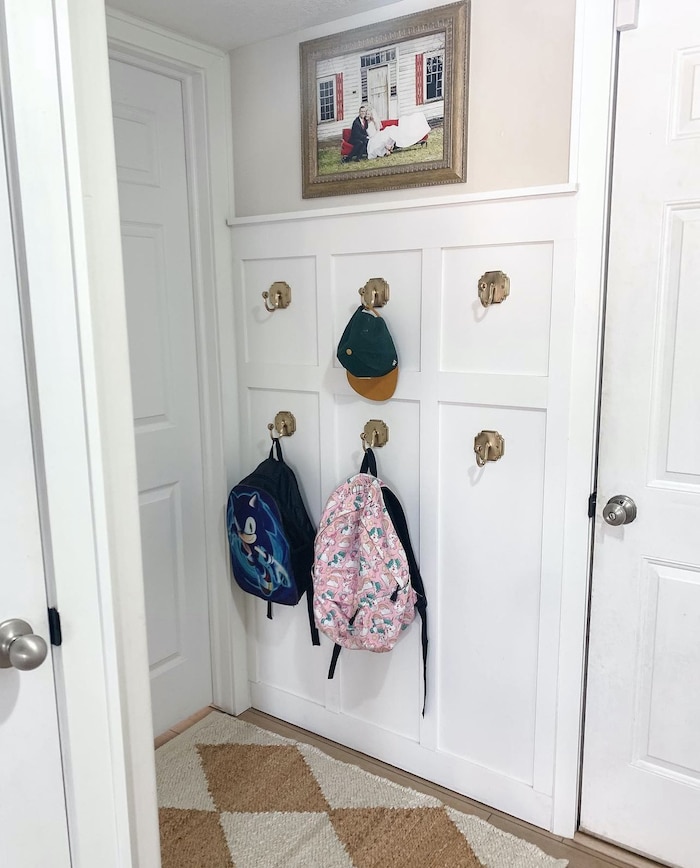 Board and Batten Mudroom with wall hooks for backpacks. Small mudroom idea.