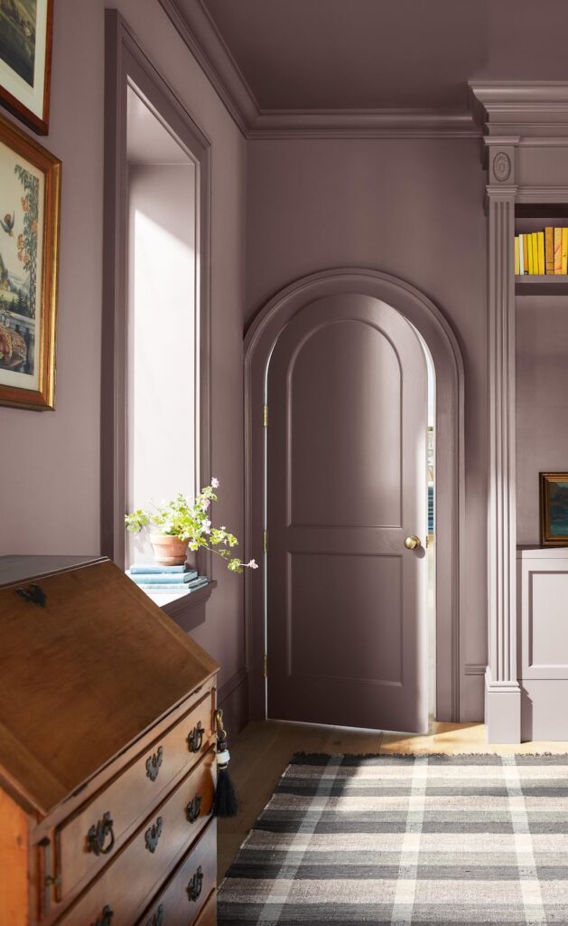 Benjamin Moore Cinnamon Slate Living Room Paint Color Idea. hallway, antique drop down desk, arch doorway, color of the year 2025, plum, brown, cozy, elegant, wall color, painting inspiration, 2025 design trends.