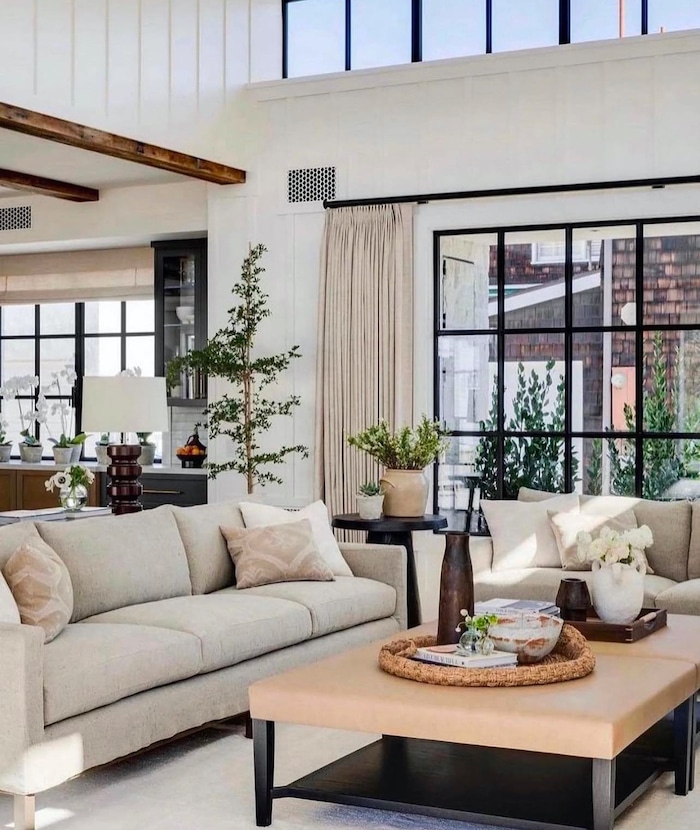 Cozy, Timeless Living Room Decor Ideas. modern organic, modern farmhouse, transitional, elegant, white walls, black windows, living room furniture arrangement with 2 sofas, open concept home layout, rustic beams