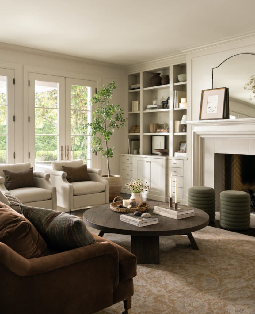 Neutral Living Room Storage, Design and Decor Ideas, decorate builtin cabinets flanking a fireplace, built in shelves, fireplace mantel decor with arch mirror and art, coffee table decor, round coffee table, ottomans, 2 chairs and sofa furniture arrangement, couch, modern, minimalist, traditional, farmhouse, organic, interior design style, neutral color palette, cozy, cosy, earthy, elegant