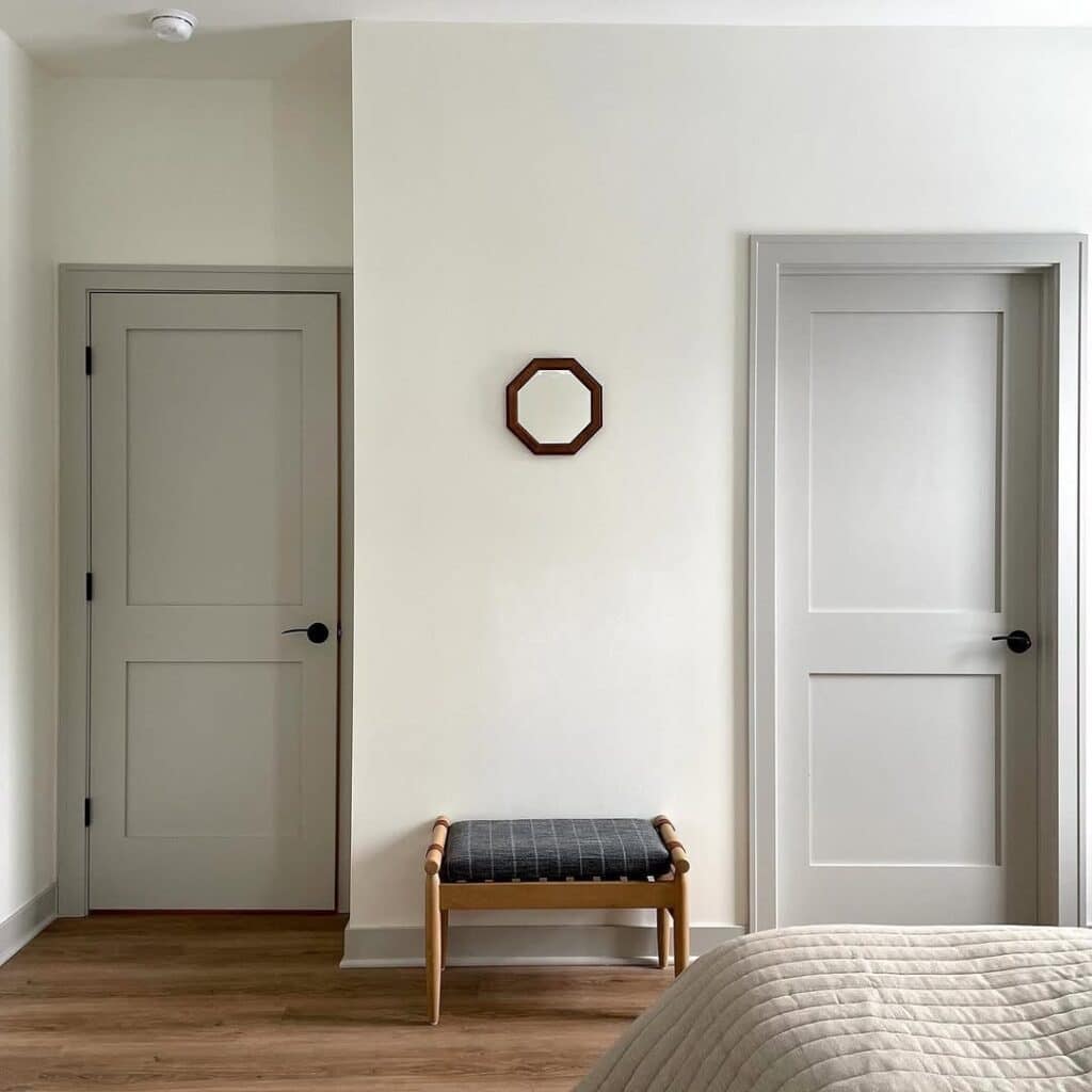 Sherwin-Williams Repose Gray interior doors and trim with black hardware, warm wood flooring, and soft neutral walls