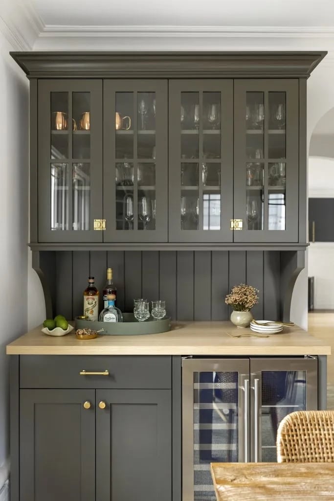 Sherwin Williams Urbane Bronze Kitchen Cabinet and Painted Beadboard Backsplash Paint Color Inspiration. dark brown, earthy, moody, neutral paint color for a traditional kitchen with butcher block countertops, brass hardware and glass front cabinets, bar area