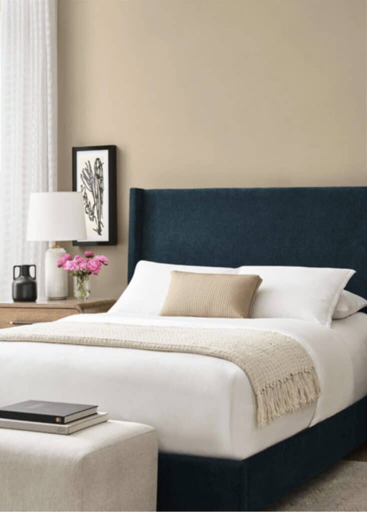 Sherwin Williams Universal Khaki Bedroom Wall Color Idea, painting idea, cozy, neutral, relaxing, calm, earthy, blue accent color, upholstered bed with bench at foot of bed, True Color Expert color advice