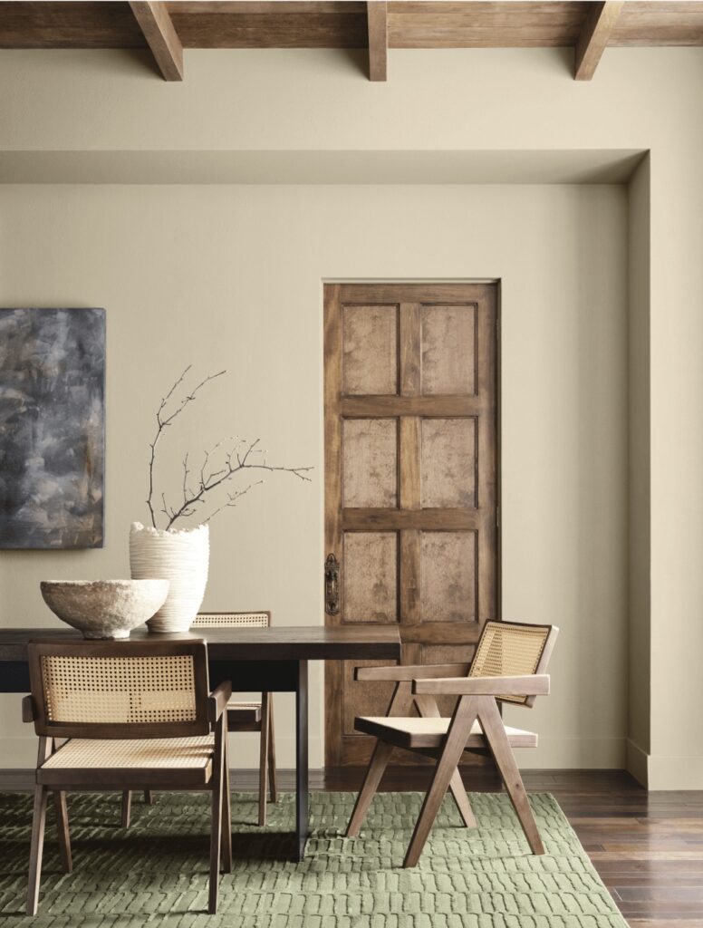 SW Sherwin Williams Universal Khaki dining room wall color paired with wood ceiling beams, green accent color and wood and rattan dining chairs, color advice from a Designer and True Color Expert, neutral, cozy, earthy, modern minimalist home inspiration