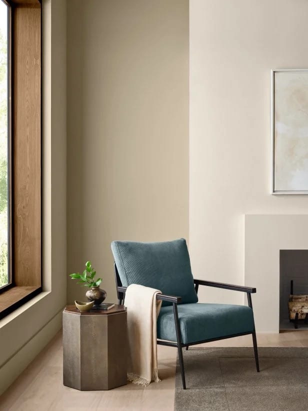Sherwin Williams Universal Khaki Living Room Wall Paint Color Idea, neutral color palette, warm, cozy nook, blue coordinating color, earthy color scheme, elegant, modern, minimalist design inspiration, plaster fireplace, wood window trim idea