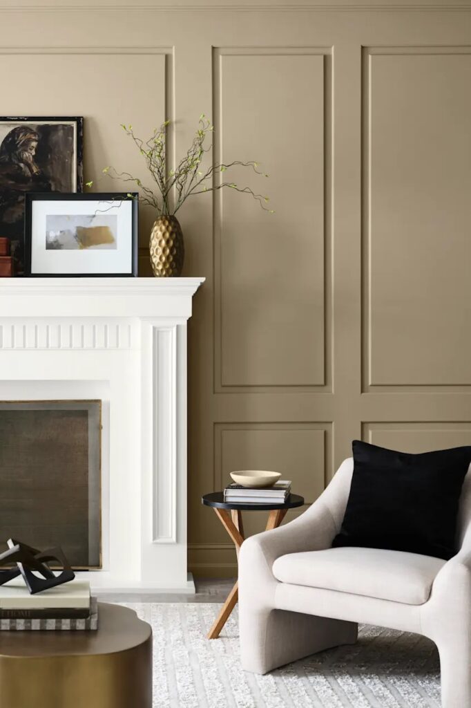 Sherwin Williams Universal Khaki Living Room Wall Color With Elegant Wall Molding and white fireplace, mix of modern and traditional style, contrast, bright living room, earthy neutral