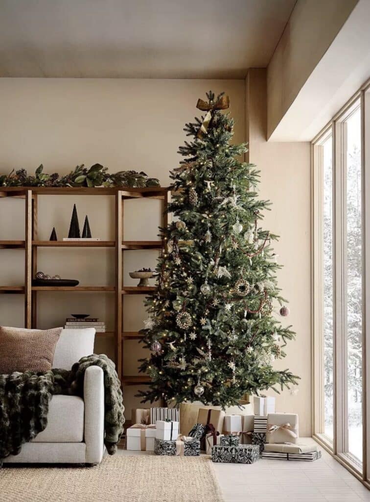 Neutral Christmas Tree Decor Ideas With Metallics, 2025 Christmas tree trend, holiday decor ideas, Christmas tree theme, cozy, living room decor with beige walls and styled bookshelf