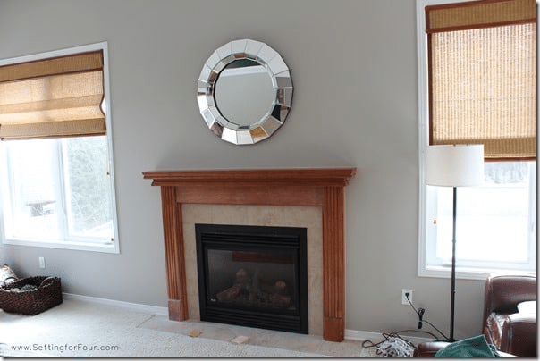 Dated orange-brown wood fireplace mantel? See how this honey oak fireplace was completely transformed with paint! This easy DIY fireplace mantel makeover includes before-and-after photos, the white paint color used, supplies and a simple 3-step tutorial for creating a brighter, more updated fireplace.