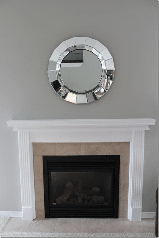 See how a white fireplace mantel makeover transformed this living room! Painting the dated wood mantel created a brighter, lighter and more updated look. Get the easy DIY painting tutorial, before-and-after photos, supply list and designer tips for a beautiful fireplace update.