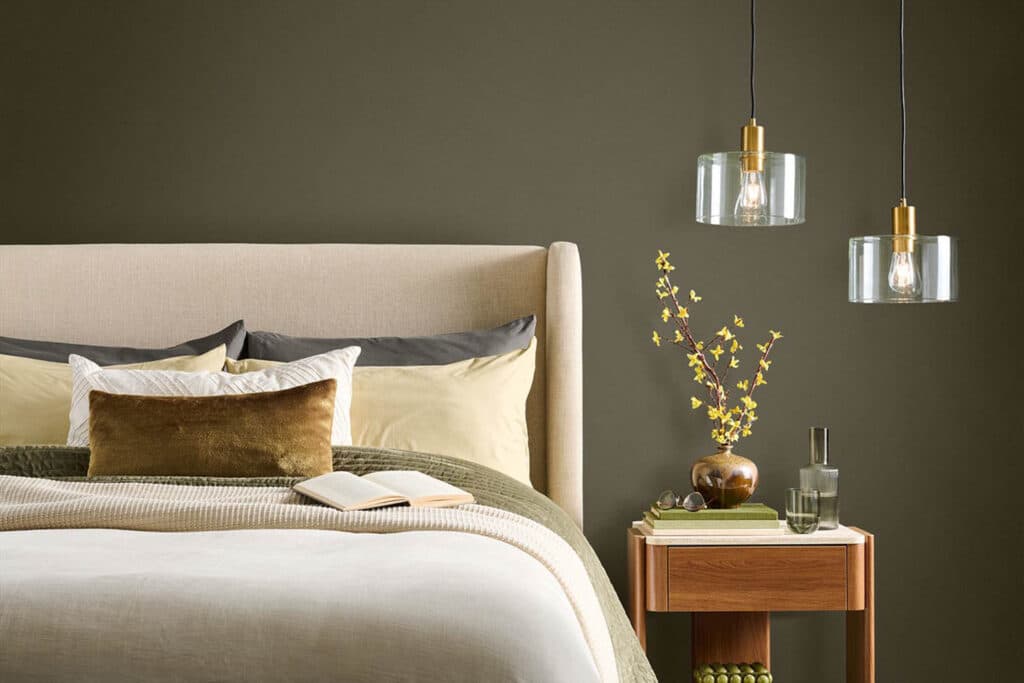 Cozy Bedroom With Behr Grounded Wall Color, paint color inspiration for a neutral bedroom, organic modern, transitional bedroom, green bedroom with upholstered bed and wood nightstand.