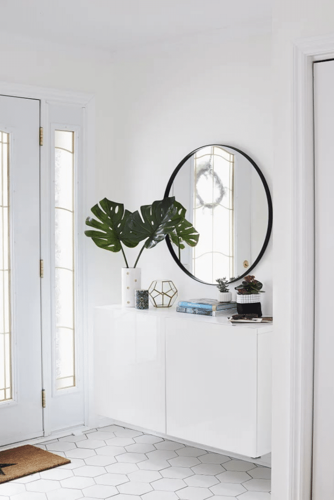 This Ikea hack using a Besta cabinet is a great way to add storage and style to a small entryway! Modern entry ideas, white foyer inspiration, Besta cabinet with a round mirror and hexagon floor tile. 2026 design trends.