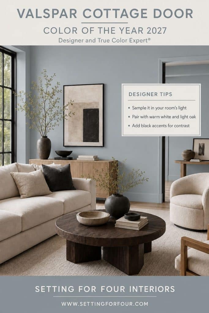 Organic modern living room with Valspar Cottage Door blue-gray walls, an ivory sofa and swivel chair, light oak cabinet, dark wood round coffee table, black-framed window and designer paint-color tips.